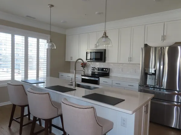 a kitchen that has a sink cabinets and stainless steel appliances