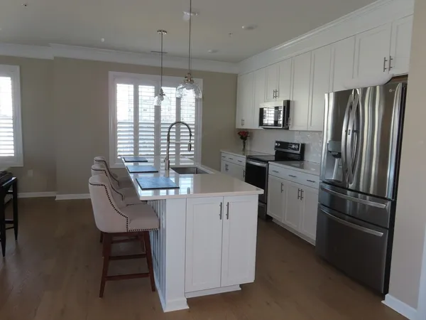 a kitchen with refrigerator a stove and furniture