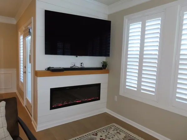 a living room with a flat screen tv and a fireplace