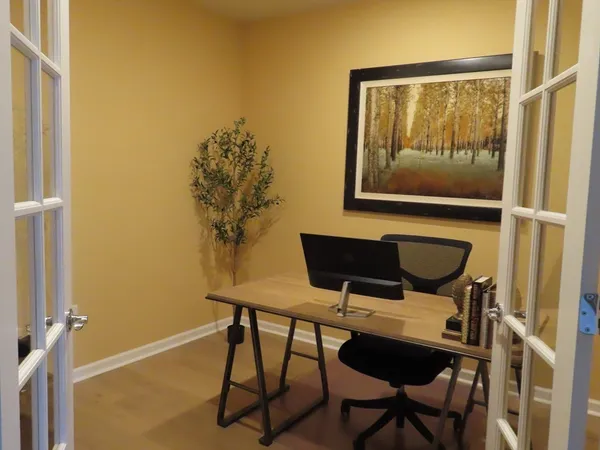 a view of a workspace with furniture and a window