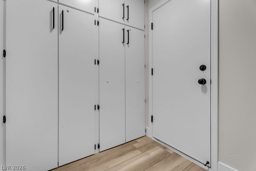 2139 Chapman Ranch Drive Henderson, NV 89012 - Photo 33 of 58 Seamless built-in cabinetry provides ample storage, complemented by warm wood flooring leading to a secure entry door.