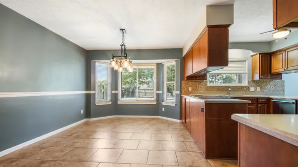 a open kitchen with granite countertop a sink dishwasher a stove and a refrigerator with wooden floor