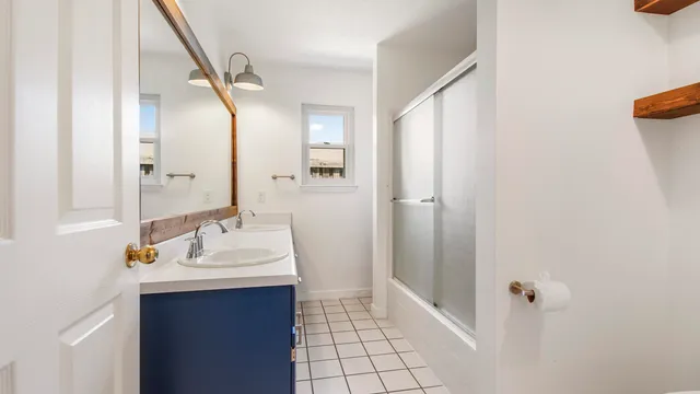 a bathroom with a sink mirror and shower