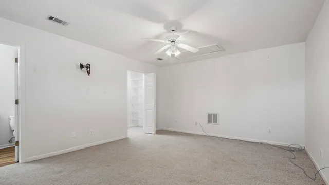 an empty room with a ceiling fan and a window