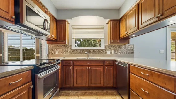 a kitchen with stainless steel appliances granite countertop a sink stove and cabinets