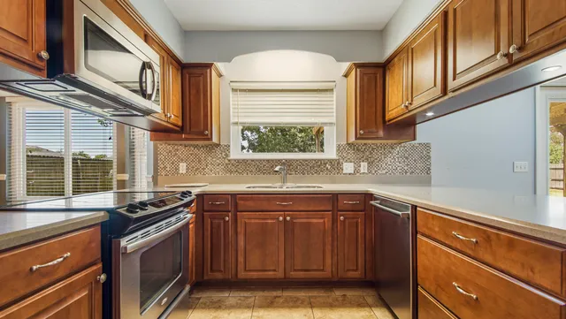 a kitchen with stainless steel appliances granite countertop a sink stove and cabinets