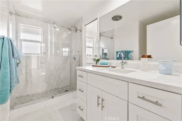a bathroom with a shower sink and mirror