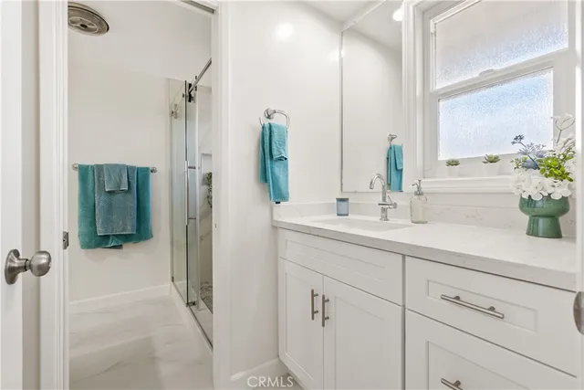 a bathroom with a shower sink and mirror