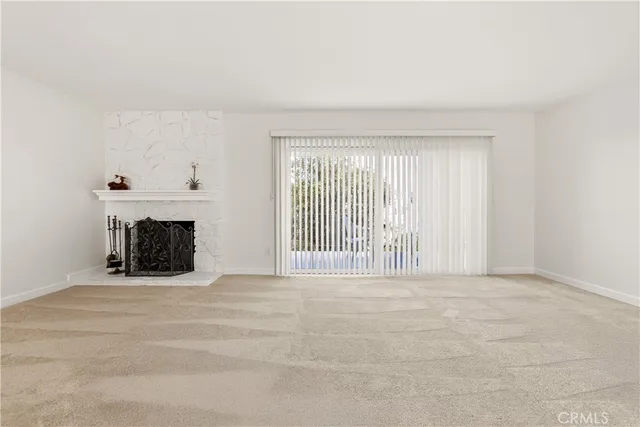 a view of an empty room with a fireplace and a window