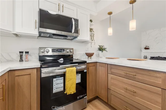 a kitchen with stainless steel appliances granite countertop a sink a stove and a microwave