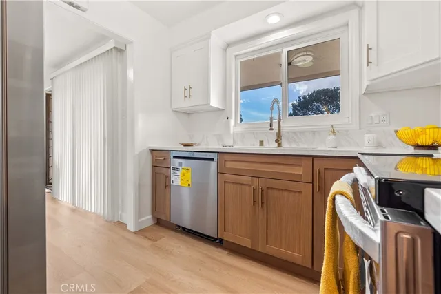 a kitchen with stainless steel appliances granite countertop a sink and wooden cabinets