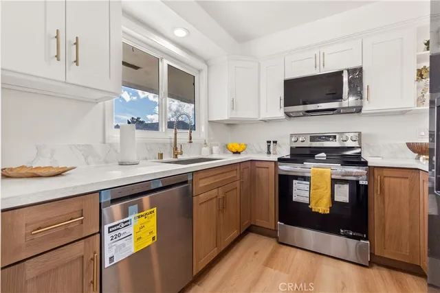 a kitchen with stainless steel appliances a stove a sink and a microwave