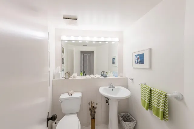 a bathroom with a toilet sink and mirror