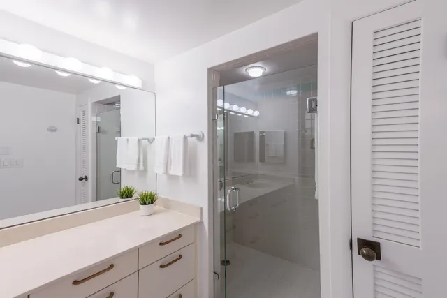 a bathroom with a shower sink and mirror