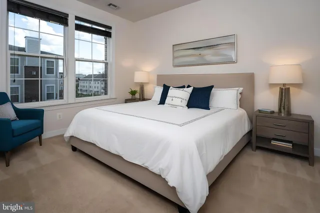 a large bed sitting in a bedroom next to a window