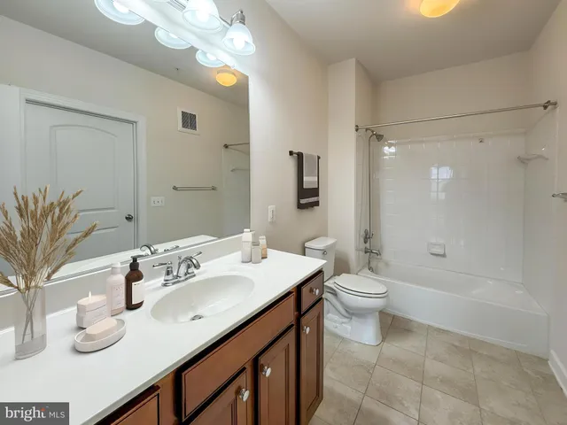a bathroom with a granite countertop sink a toilet and shower