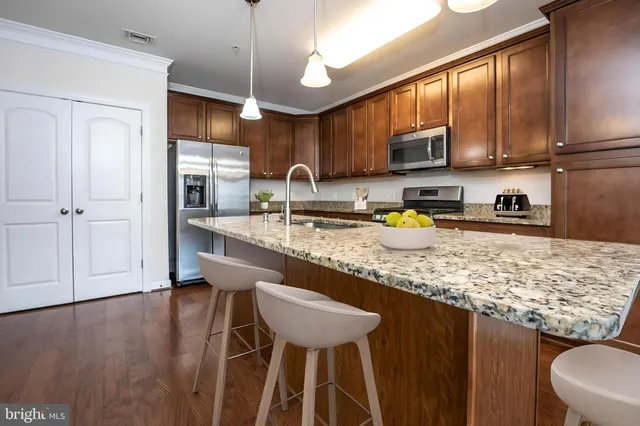 a kitchen with stainless steel appliances granite countertop a sink refrigerator and cabinets