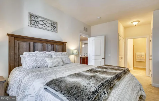 a bedroom with a large bed and a chandelier