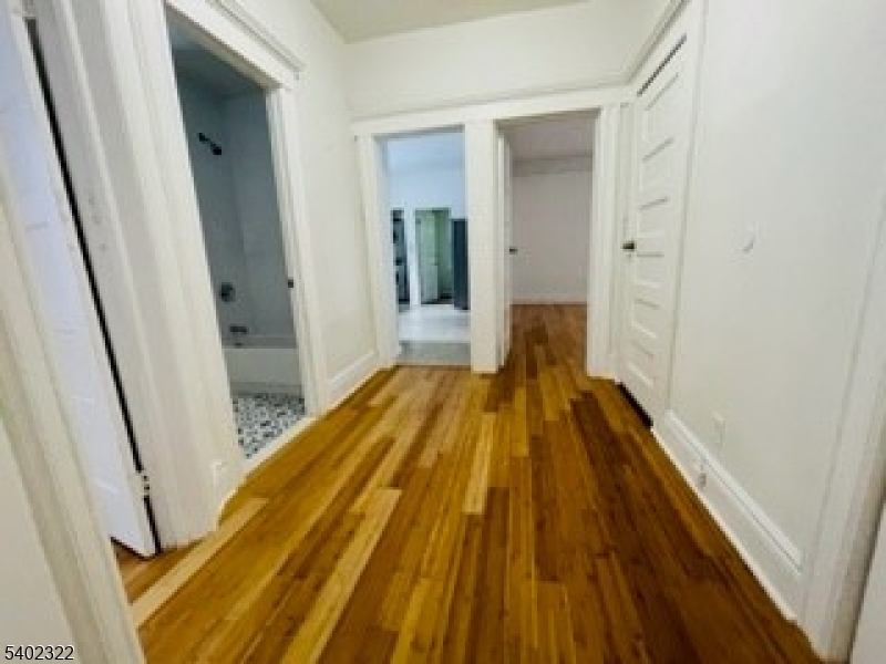 169 Hillside Avenue, Unit 2 Glen Ridge, NJ 07028 - Photo 5 of 10 a view of a hallway with wooden floor and furniture