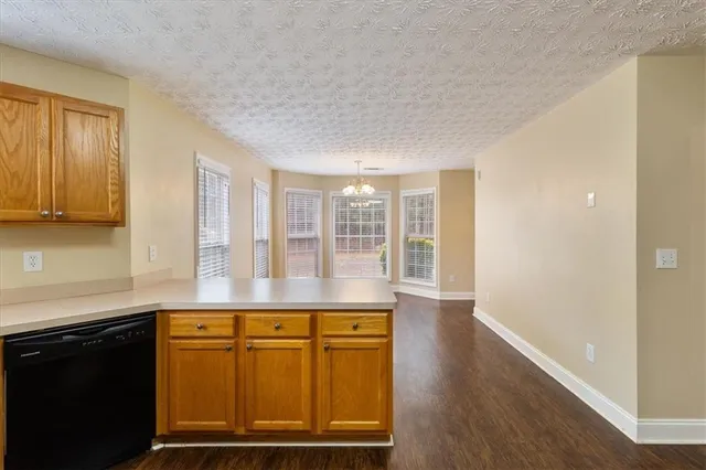 a view of a kitchen with wooden floor and cabinets
