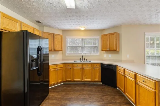 a large kitchen with granite countertop a refrigerator stove and sink