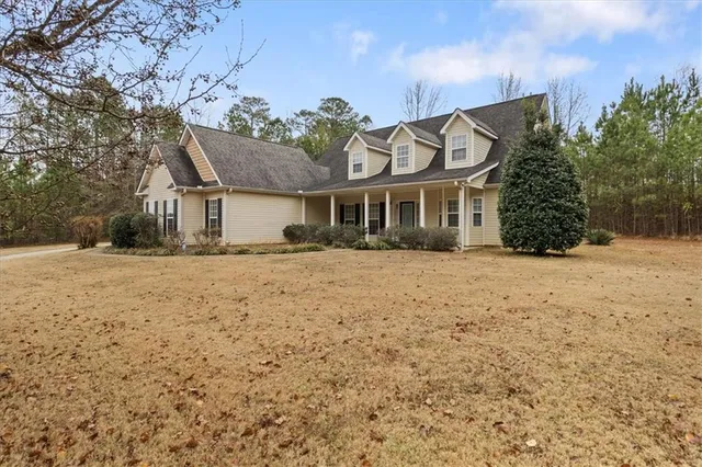a front view of a house with a yard covered in snow