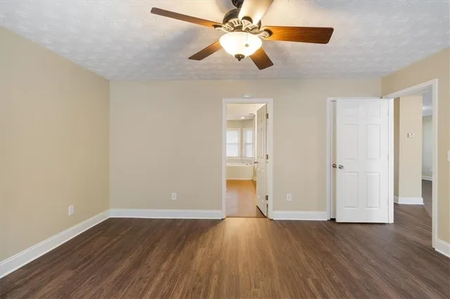 an empty room with wooden floor chandelier fan and closet area