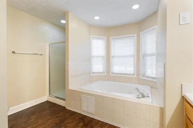 a spacious bathroom with a tub shower and sink