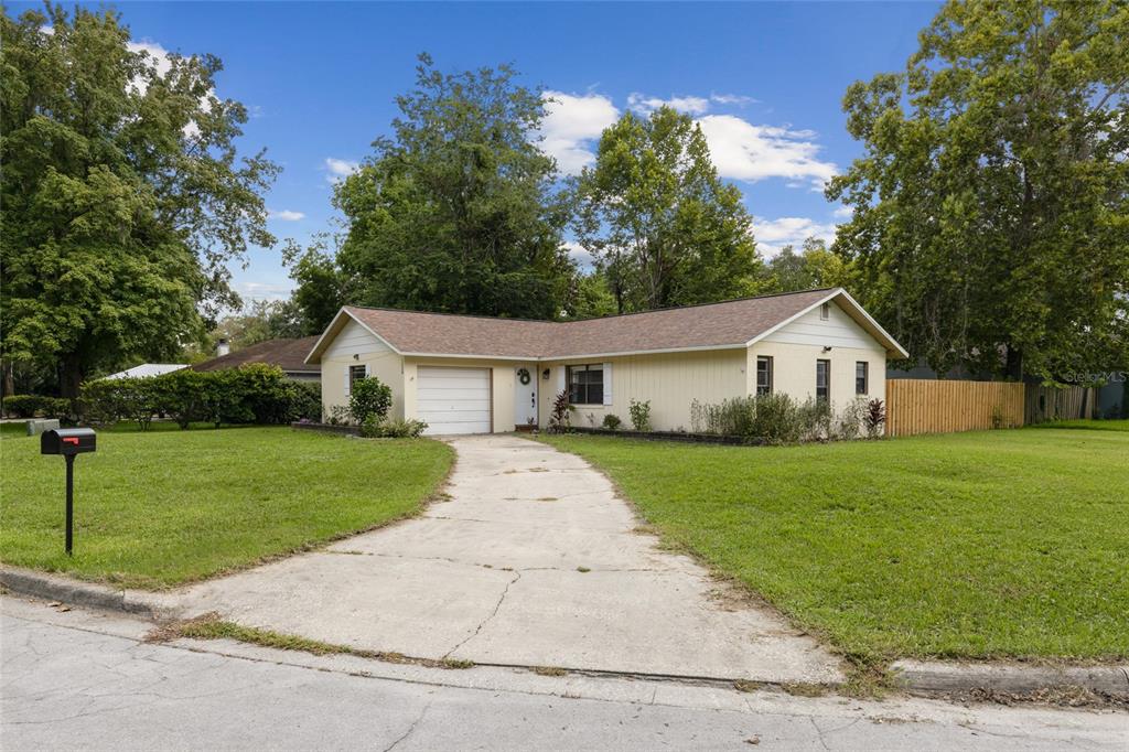 1228 Southwest 75th Drive Gainesville, FL 32607 - Photo 1 of 17 a front view of a house with a yard and trees