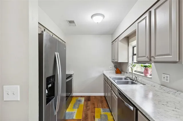 a kitchen with stainless steel appliances granite countertop a sink stove and refrigerator
