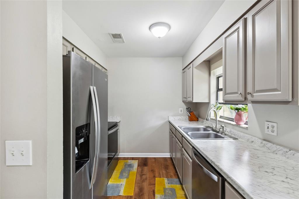 1228 Southwest 75th Drive Gainesville, FL 32607 - Photo 13 of 17 a kitchen with stainless steel appliances granite countertop a sink stove and refrigerator
