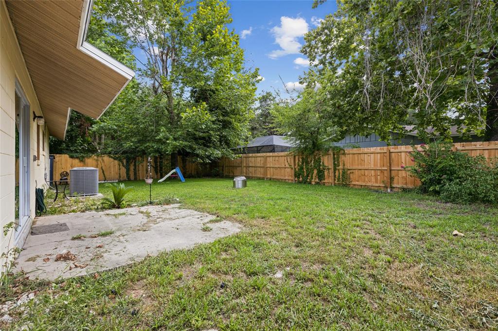 1228 Southwest 75th Drive Gainesville, FL 32607 - Photo 16 of 17 a backyard of a house with a garden and plants