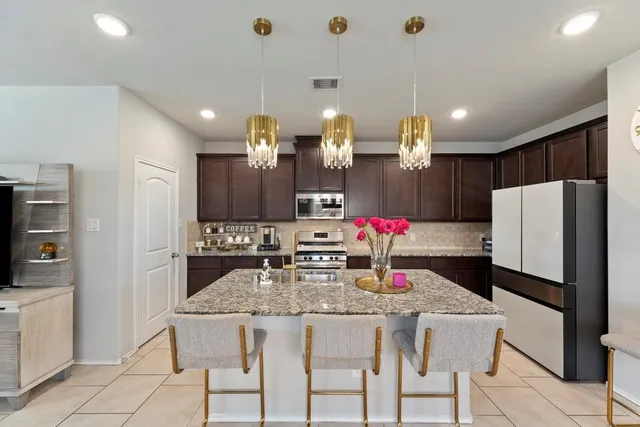 a kitchen with refrigerator and chairs
