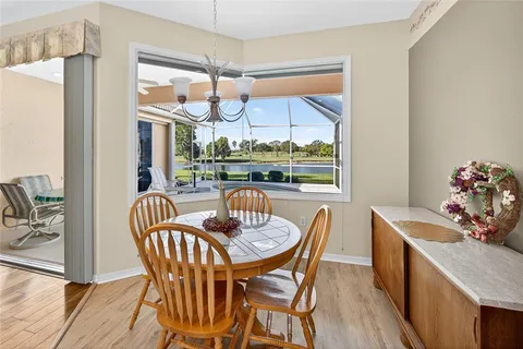 a dining room with furniture a chandelier and wooden floor