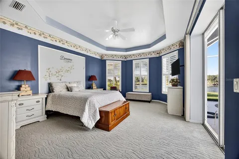 a spacious bedroom with a large bed and a chandelier