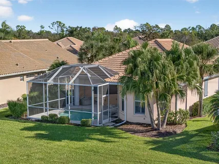 a view of a house with backyard and a tree