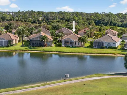 an aerial view of residential houses with outdoor space and lake view