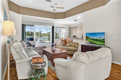 a living room with furniture a chandelier and a large window
