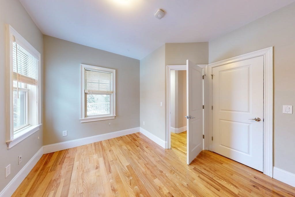 201 Pearl Street, Unit 2 Cambridge, MA 02139 - Photo 11 of 16 a view of an empty room with wooden floor and a window