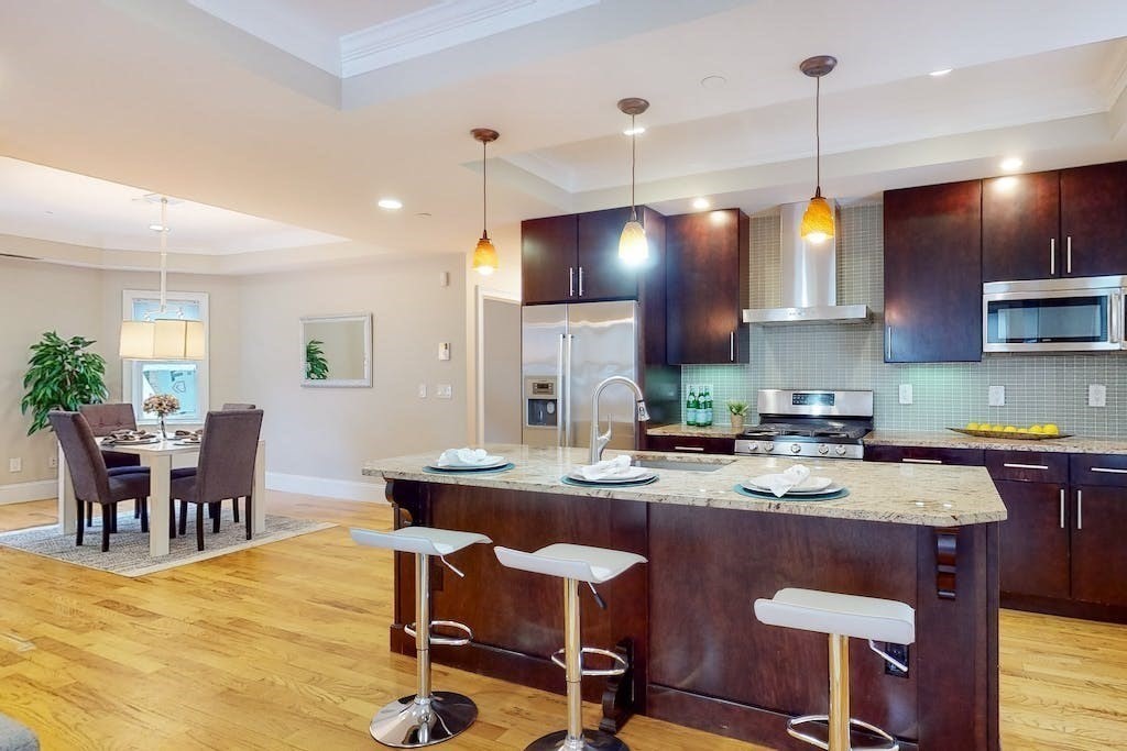201 Pearl Street, Unit 2 Cambridge, MA 02139 - Photo 4 of 16 a kitchen with a dining table chairs and wooden floor