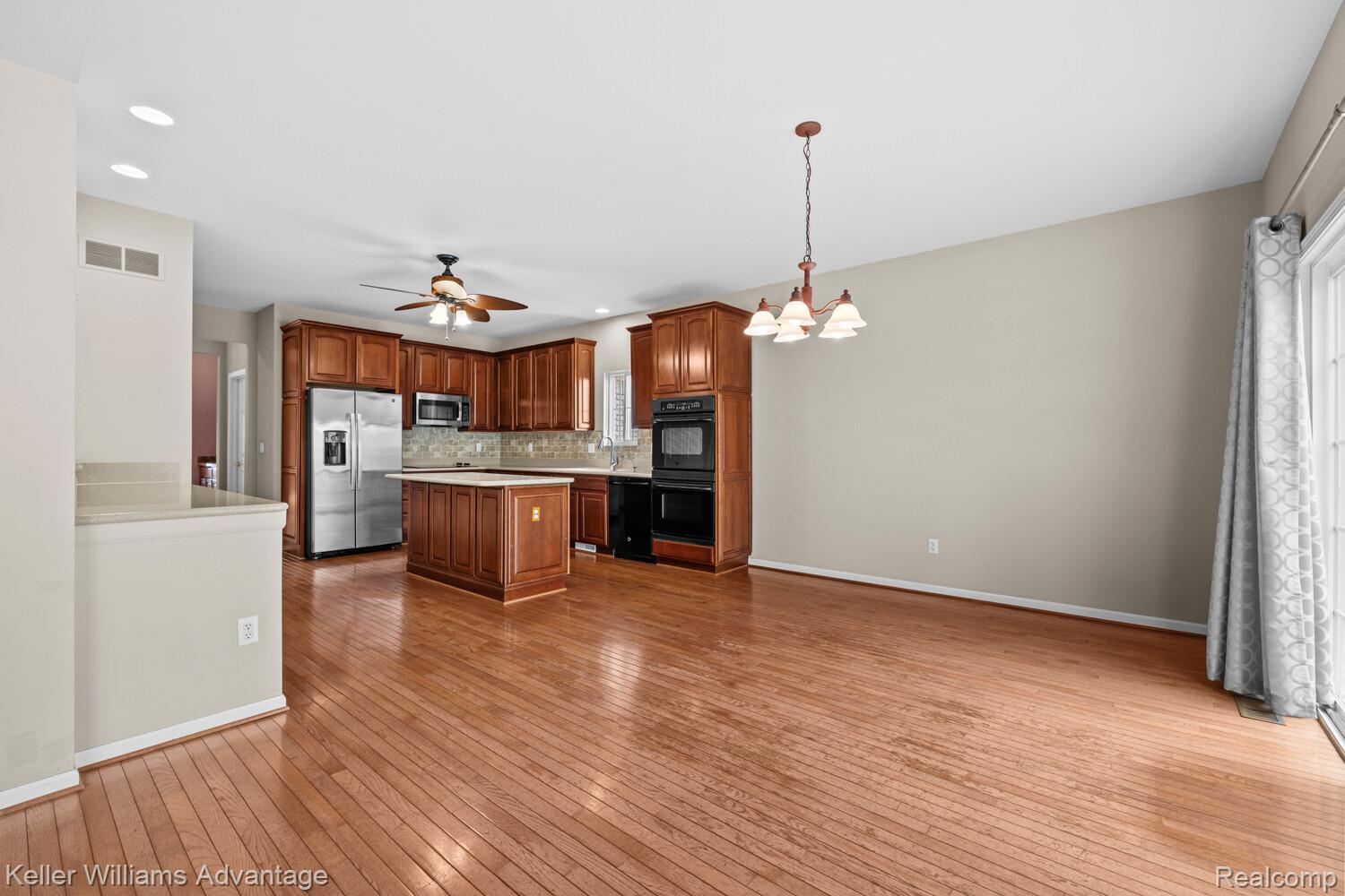 4100 Norwich Court Rochester, MI 48306 - Photo 19 of 72 Kitchen with suspended lighting, light countertops, black appliances, a center island, and light wood-style floors