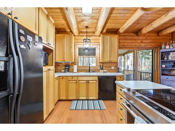 a dining room with wooden floor a table and kitchen view
