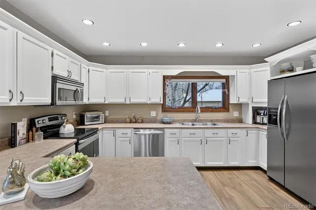 a kitchen with stainless steel appliances a sink stove and cabinets