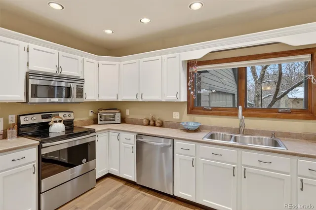 a kitchen with granite countertop white cabinets and white appliances
