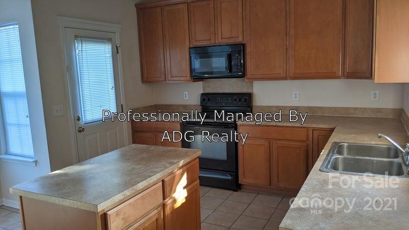 6336 Trotters Ridge Road Charlotte, NC 28227 - Photo 2 of 7 a kitchen with stainless steel appliances granite countertop a stove a sink and a microwave