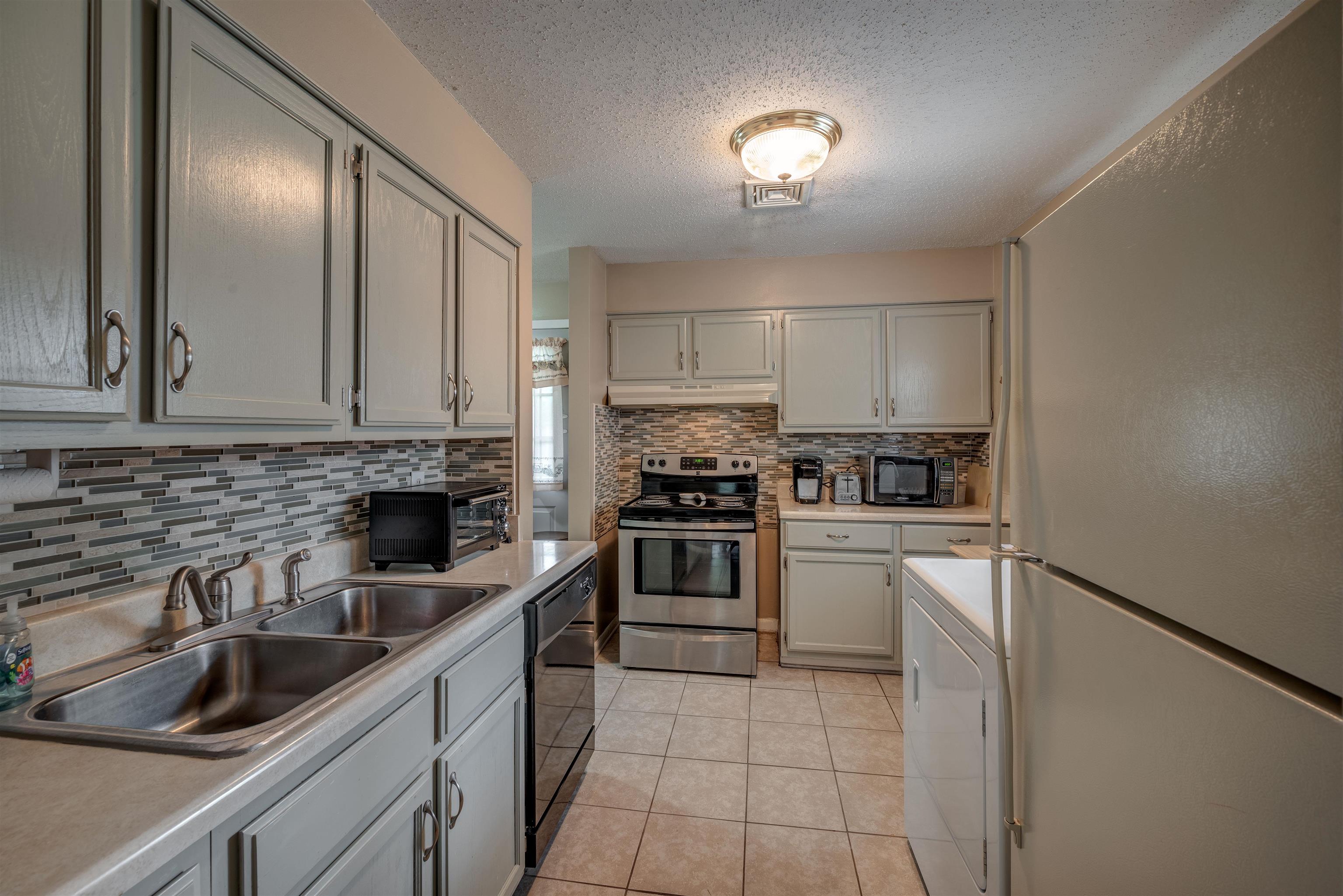 450 Malboro Road Memphis, TN 38120 - Photo 5 of 16 a kitchen with a sink cabinets and stainless steel appliances
