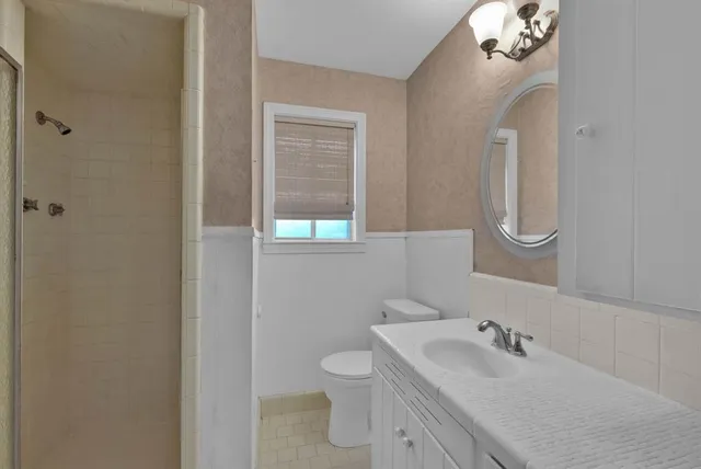 a bathroom with a toilet a sink and mirror