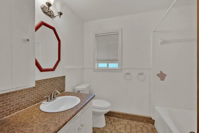 a view of an empty room with chandelier fan