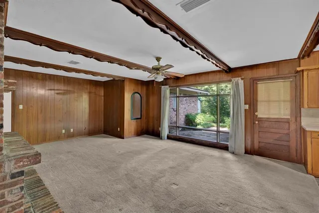 en empty room with windows and ceiling fan