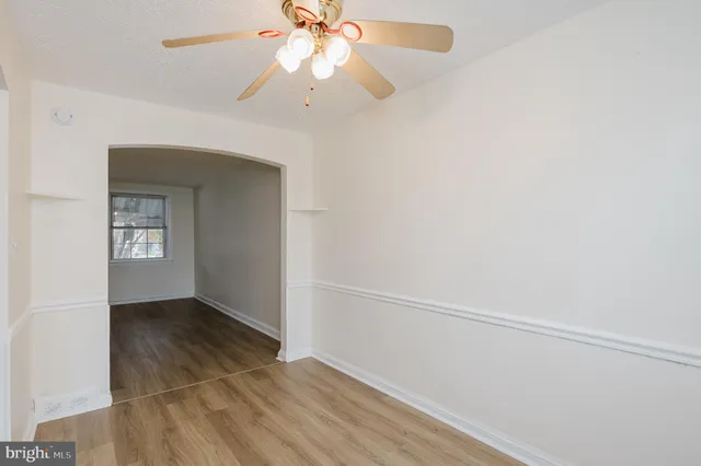 an empty room with a fan and a window